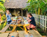 Un uomo e una donna seduti a un tavolo da picnic di Arusha Jua Eco Home- on coffee farm ad Arusha