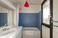 a bathroom with a tub and a sink and a red light at 120 Grenelle - Spacieux Duplex avec vue sur la tour Eiffel in Paris