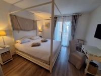 a bedroom with a canopy bed and a desk at Best Western L&#39;Orangerie in Nîmes