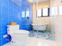 a blue tiled bathroom with a toilet and a tub at Elegance House in Wujie