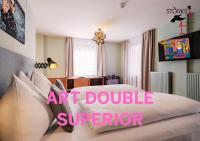 a bedroom with a large bed with a pink sign at Hotel Bad Hofgastein - The STORKS - Adults Only in Bad Hofgastein