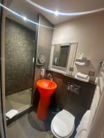 a bathroom with a red toilet and a shower at Hotel Des Lices in Rennes