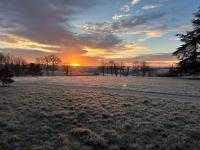 a frosty field with the sun setting in the background at Chambres d&#39;hôtes Saint Jean in Nogent-le-Rotrou