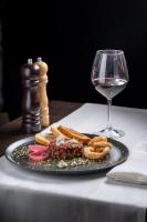 a plate of food and a glass of wine on a table at Europa Royale Bucharest in Bucharest