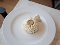 Un plato blanco con una flor encima. en Novotel Megève Mont-Blanc, en Megève