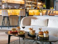 una mesa con comida y copas de vino en un sofá en Novotel Megève Mont-Blanc, en Megève