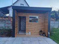 a small wooden shed with a porch in a yard at Magnifique petite maison 