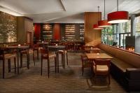 Un restaurante con mesas y sillas y un bar. en The Westin Bellevue, en Bellevue