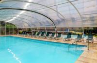 a swimming pool with a glass roof over it at Camping La Mignardière in Ballan-Miré