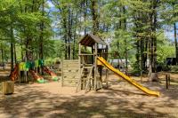 a playground with a slide and a play structure at Camping La Mignardière in Ballan-Miré