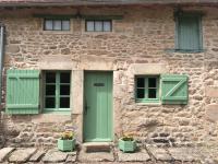 a stone building with green doors and windows at Morvan La Pastourelle in Quarré-les-Tombes