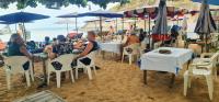 een groep mensen die onder parasols op het strand zitten bij Boonsong Guest House in Khao Tao