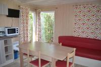 a living room with a table and a red couch at Camping La Mignardière in Ballan-Miré
