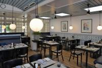 ハノーファーにあるベストウエスタン プレミア パークホテル クロンスベルクのテーブルと椅子、ペンダントライト付きのレストラン