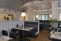 ハノーファーにあるベストウエスタン プレミア パークホテル クロンスベルクのテーブルと椅子と時計のあるダイニングルーム