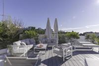 un patio avec des chaises, des tables et des parasols dans l&#39;établissement Luxury Penthouse Montfleury, à Cannes