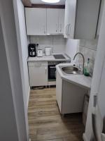 a small kitchen with white cabinets and a sink at Garage studio in Bistriţa