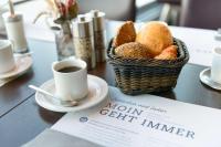 a basket of bread and a cup of coffee on a table at Atlantic Hotel Sail City in Bremerhaven