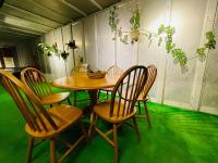 a table and chairs in a room with green grass at Follow Me designed B&amp;B in Dongshan