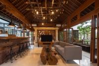 een woonkamer met een bank en een televisie bij Paripadi Private Villa and Sanctuary in Canggu