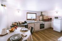 a kitchen with a table and a white refrigerator at La Petite Maison in Bonvillard