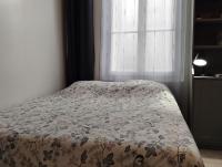 a bed in a bedroom with a floral bedspread at Le Studio de la Seine in Elbeuf