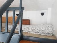 a bed in a small room with a staircase at Le Studio de la Seine in Elbeuf