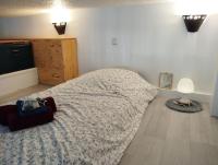 a bedroom with a large bed and a wooden floor at Le Studio de la Seine in Elbeuf