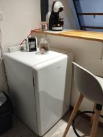 a small white refrigerator in a room with a table at Le Studio de la Seine in Elbeuf