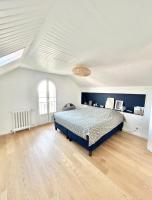 a large bedroom with a bed and a wooden floor at Maison familiale avec vue tour Eiffel in Suresnes
