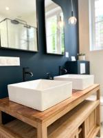 a bathroom with two white sinks on a wooden counter at Maison familiale avec vue tour Eiffel in Suresnes