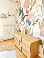 a room with a dresser and a wall with flowers at Maison familiale avec vue tour Eiffel in Suresnes