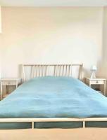 a bed with a blue blanket on top of it at Maison familiale avec vue tour Eiffel in Suresnes