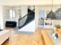 a living room with a staircase and a couch at Maison familiale avec vue tour Eiffel in Suresnes