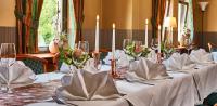 a set of tables with white table linen and flowers at Teichhotel in Schmalkalden