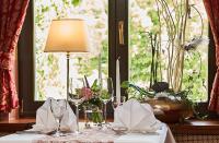 a table with a lamp and wine glasses on it at Teichhotel in Schmalkalden