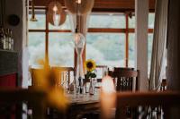 einen Tisch mit Sonnenblume in einem Zimmer mit Fenster in der Unterkunft Hotel-Restaurant Eifeler Seehütte in Rieden