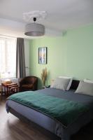 a bedroom with a large bed with a green blanket at Au Pied du Viaduc in Morlaix