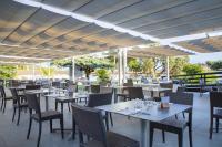 een restaurant met tafels en stoelen onder een luifel bij Cormoran Hotel & Residence in Villasimius