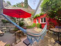 a hammock with a red umbrella on a patio at charmante maisonnette in Le Havre