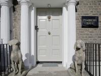 two statues of sheep standing in front of a door at Pembroke Hall in Dublin