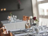 a table with wine glasses and a rose in a vase at Skagen Strand Holiday Center in Hulsig