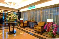 a lobby with chairs and a table with flowers at Jingan Classic Inn in Zhonghe