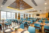 a dining room with tables and blue chairs at TGT BEACH HOTEL in Da Nang
