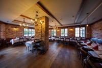 comedor con mesas, sillas y paredes de ladrillo en WELCOME HOTEL - Hellbühl Self-Check-in, en Hellbühl