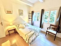 a bedroom with a bed and a chair and windows at La Marjolette by Welcome to Cannes in Cannes