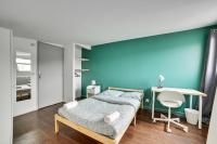 ein Schlafzimmer mit einer blauen Wand, einem Bett und einem Schreibtisch in der Unterkunft Chic and spacious apart with parking in Paris in Pierrefitte-sur-Seine