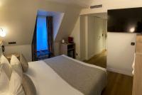 Un dormitorio con una gran cama blanca y una ventana en XO Hotel Paris, en París
