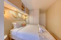 a bedroom with a large white bed with pillows at La pépite bleue de Nanterre in Nanterre