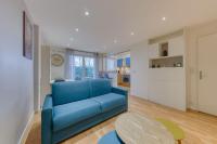 a blue couch in a living room with a table at La pépite bleue de Nanterre in Nanterre